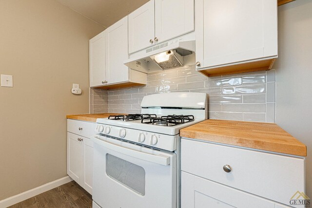 kitchen with dark wood-style flooring, backsplash, baseboards, under cabinet range hood, and white range with gas cooktop