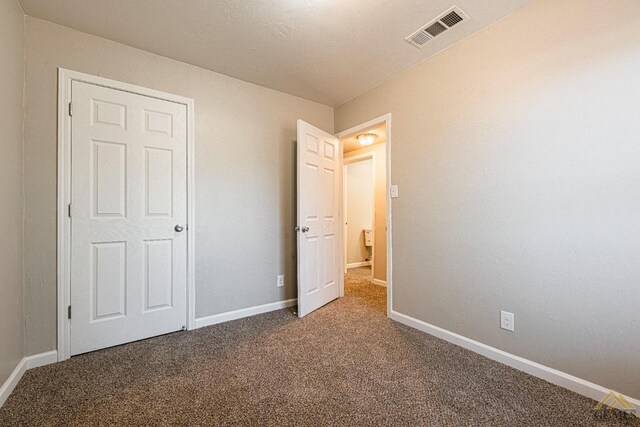 unfurnished bedroom featuring carpet floors, baseboards, and visible vents