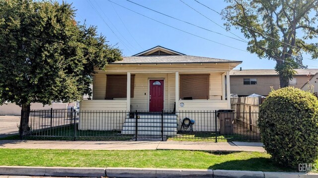 view of front of property featuring a porch, a fenced front yard, and a gate