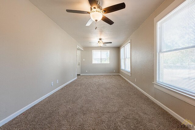 carpeted empty room featuring baseboards and ceiling fan