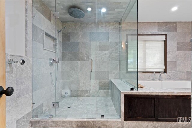 full bath featuring recessed lighting, a stall shower, and tile walls