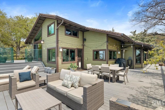 back of house featuring outdoor dining area, an outdoor hangout area, and a deck