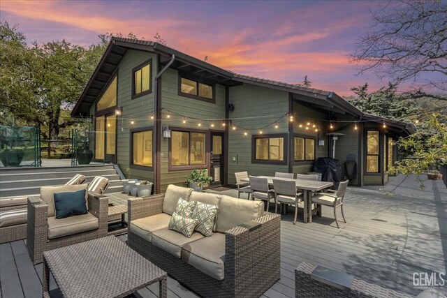back of property featuring a deck, outdoor lounge area, and outdoor dining space