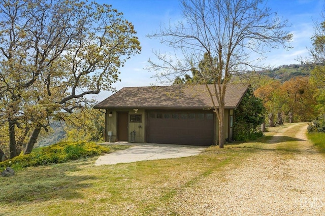view of front of house featuring an attached garage, a front lawn, and driveway