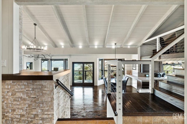 interior space with a notable chandelier, lofted ceiling with beams, french doors, stairs, and wood finished floors