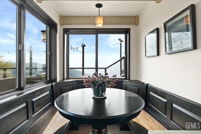 dining space with a wainscoted wall and wood finished floors