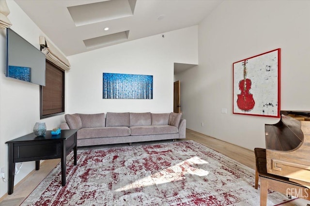 living room featuring visible vents, light wood finished floors, and vaulted ceiling