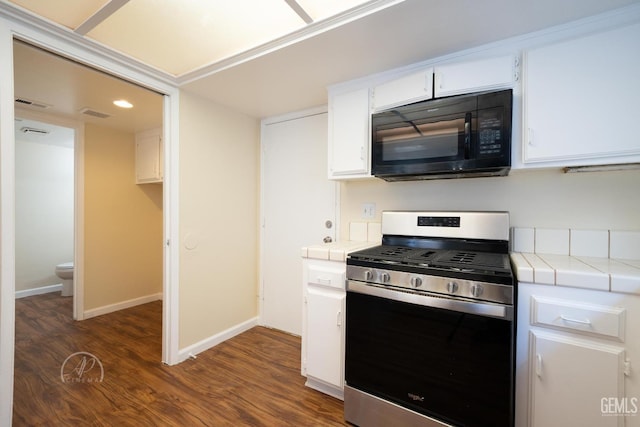 kitchen with dark hardwood / wood-style floors, tile countertops, gas stove, and white cabinets