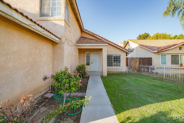 entrance to property featuring a yard