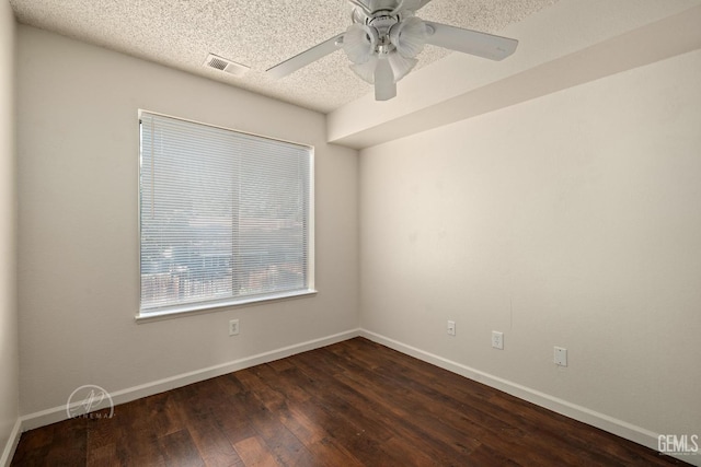 spare room with ceiling fan, dark hardwood / wood-style floors, and a textured ceiling