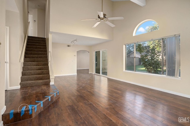 unfurnished living room featuring beamed ceiling, dark hardwood / wood-style flooring, high vaulted ceiling, and ceiling fan