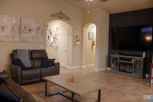 9512 Four Pines Dr, Shafter, CA 93263 - living room with arched walkways, light tile patterned flooring, a ceiling fan, and baseboards