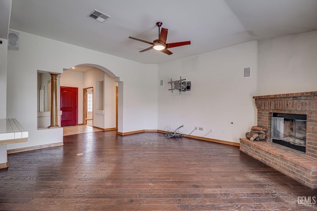 unfurnished living room featuring hardwood / wood-style floors, a brick fireplace, and ceiling fan