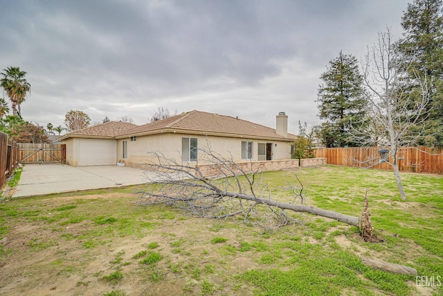 back of property with a yard and a patio