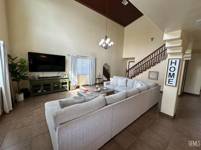 living area featuring a chandelier, stairs, tile patterned floors, and a high ceiling