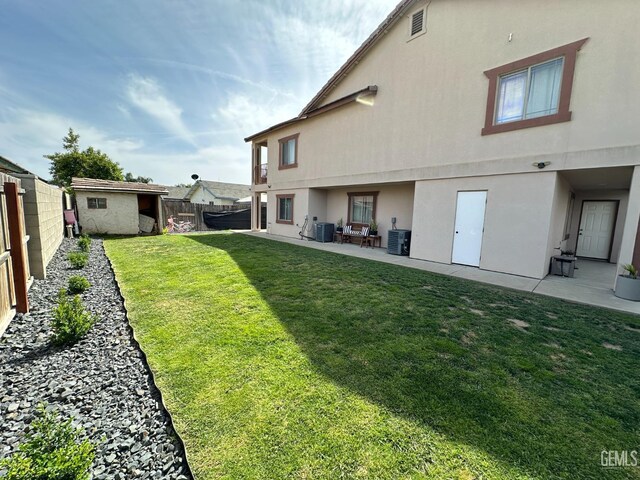 rear view of house with cooling unit, a patio, stucco siding, and a fenced backyard