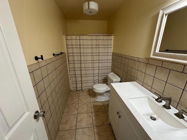 full bath featuring tile walls, wainscoting, tile patterned floors, and toilet