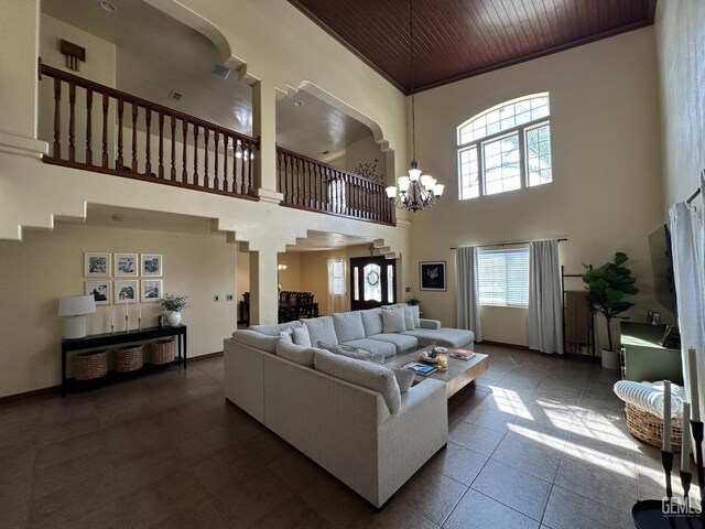 tiled living area with a towering ceiling, wooden ceiling, and a chandelier