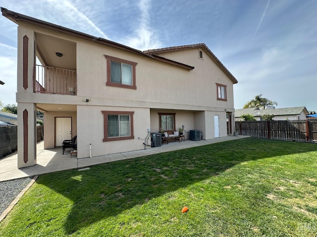 rear view of property with stucco siding, a patio area, a balcony, and central air condition unit