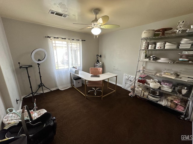 interior space with dark colored carpet, visible vents, a ceiling fan, and baseboards
