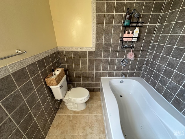 full bath featuring tile patterned floors, wainscoting, tile walls, toilet, and a bathtub