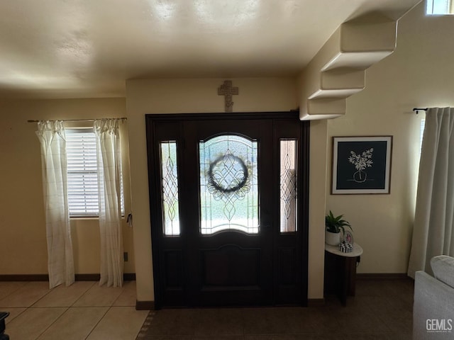 foyer with light tile patterned floors and baseboards