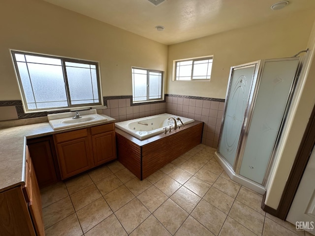 bathroom with tile walls, a shower stall, vanity, a whirlpool tub, and tile patterned flooring