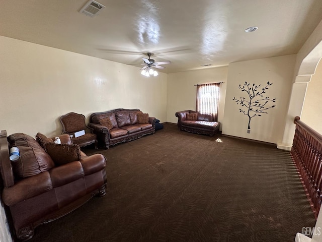 living area featuring dark carpet, visible vents, and ceiling fan