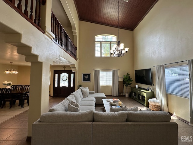 tiled living area featuring ornamental molding, wooden ceiling, a notable chandelier, and a high ceiling