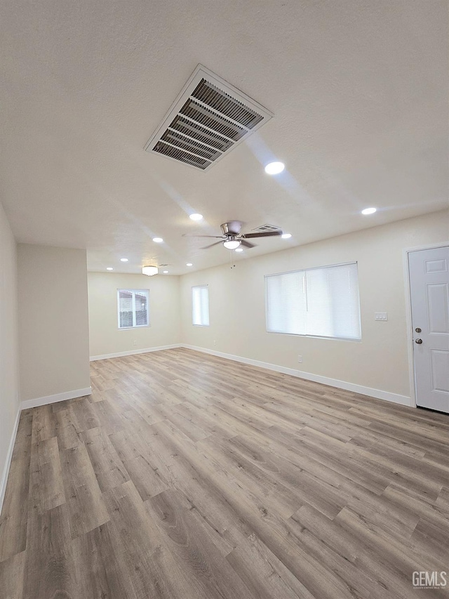 unfurnished room featuring a ceiling fan, baseboards, visible vents, light wood-style flooring, and recessed lighting