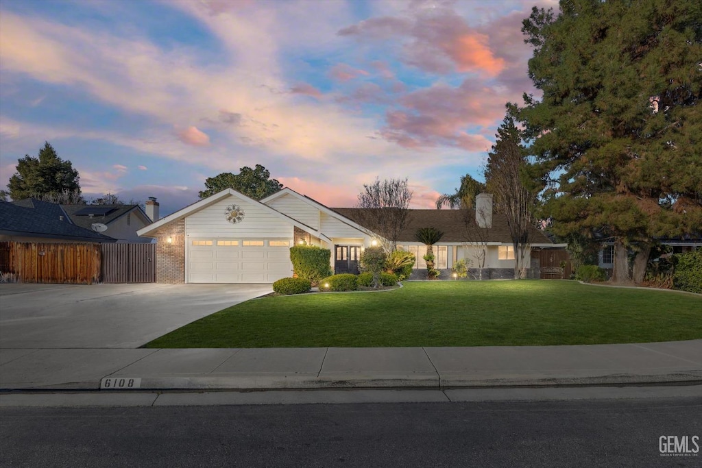 ranch-style home with a garage and a lawn