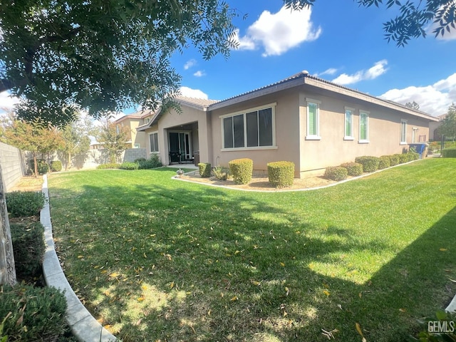 rear view of property featuring a lawn