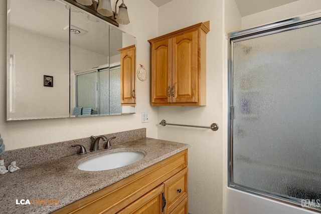 bathroom featuring vanity and combined bath / shower with glass door