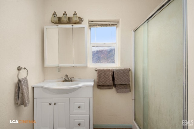 bathroom with vanity and a shower with door