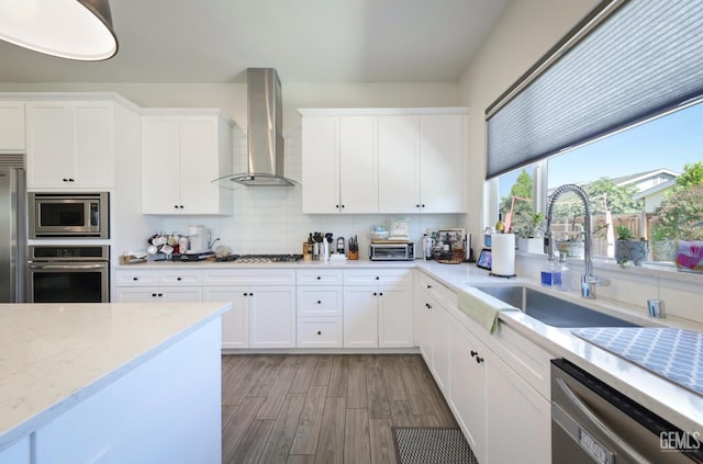 9108 Manor Forest Ln, Shafter, CA 93263 - kitchen with built in appliances, wall chimney exhaust hood, light wood-style flooring, decorative backsplash, and white cabinets