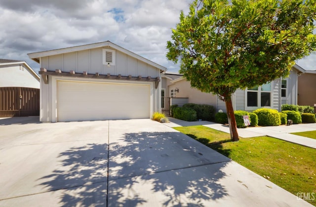 9108 Manor Forest Ln, Shafter, CA 93263 - view of front of house with board and batten siding, concrete driveway, an attached garage, and a front yard