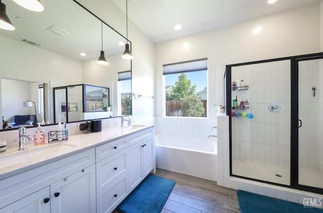 9108 Manor Forest Ln, Shafter, CA 93263 - bathroom with wood finished floors, double vanity, a bath, a stall shower, and recessed lighting