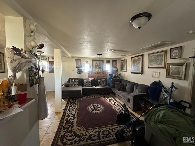 tiled living room featuring a textured ceiling