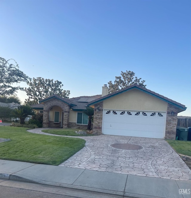 ranch-style house featuring a garage and a front lawn