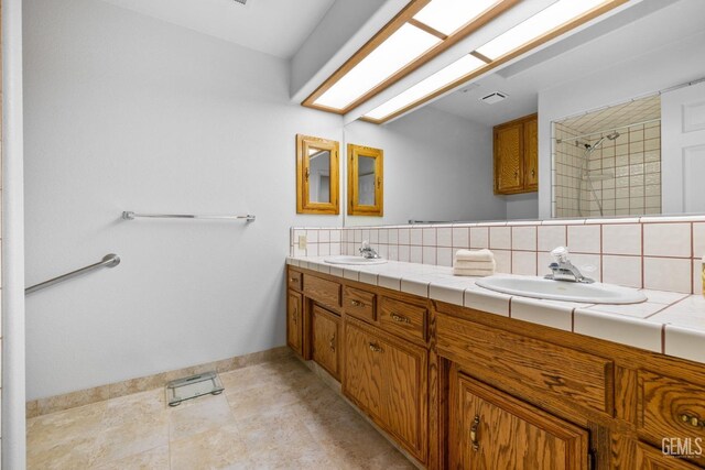 14013 Laverton Ave, Bakersfield, CA 93314 - bathroom with double vanity, backsplash, baseboards, a tile shower, and tile patterned flooring