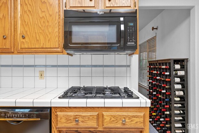 14013 Laverton Ave, Bakersfield, CA 93314 - kitchen with black microwave, dishwashing machine, tile counters, stainless steel gas cooktop, and backsplash