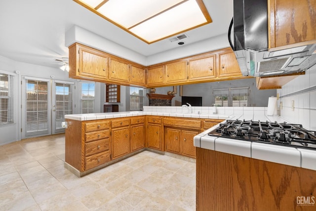 14013 Laverton Ave, Bakersfield, CA 93314 - kitchen with brown cabinets, black gas cooktop, a peninsula, and ceiling fan