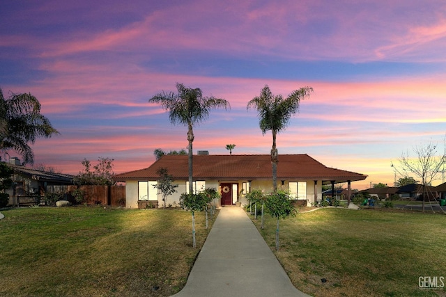 single story home with a lawn