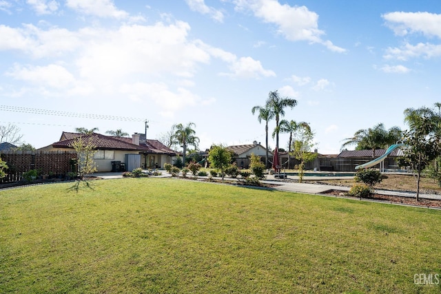 view of yard with a playground and a fenced in pool