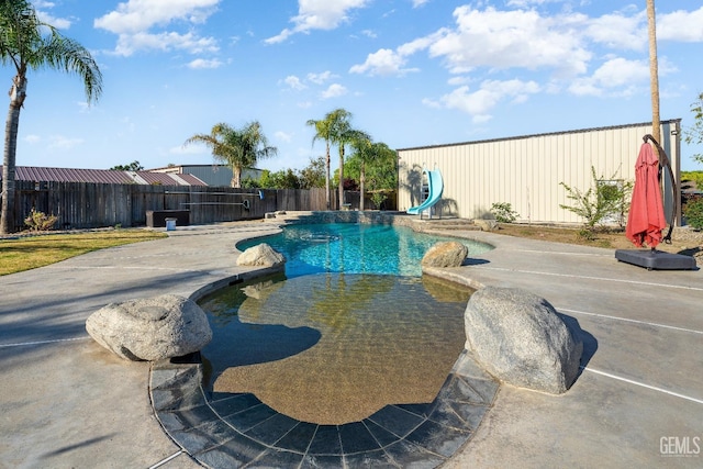 view of swimming pool featuring a water slide and a patio