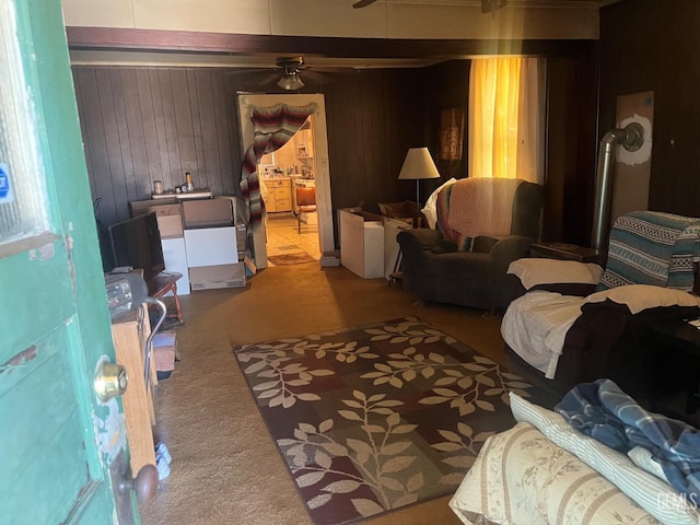 living room featuring wood walls, ceiling fan, and carpet flooring