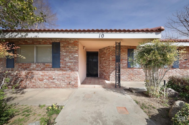 doorway to property featuring brick siding