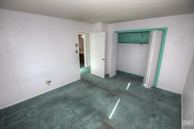 unfurnished bedroom featuring a textured ceiling, a closet, and dark colored carpet