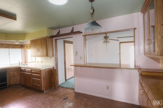 kitchen featuring ceiling fan, tile countertops, pendant lighting, and sink