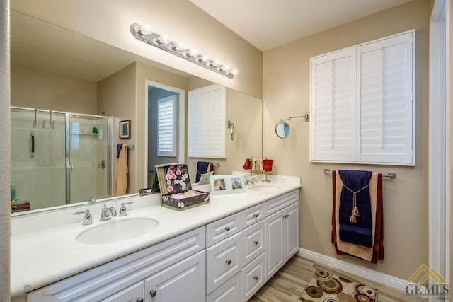 bathroom with wood-type flooring, vanity, and walk in shower